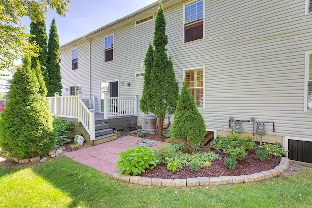 back of property featuring crawl space, a lawn, central AC, and a deck