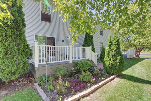 back of house featuring a wooden deck and a yard