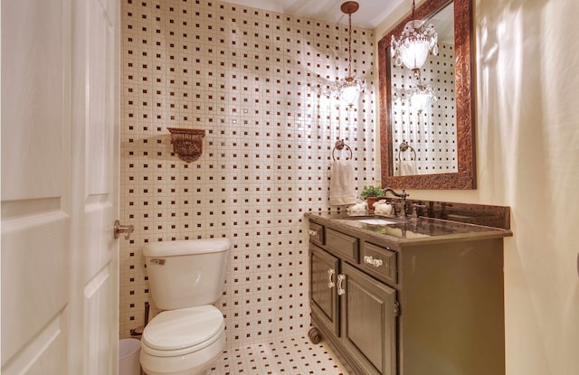 half bath with tile walls, toilet, and vanity