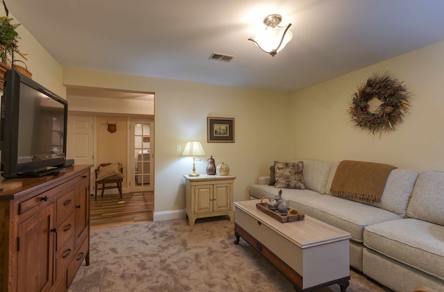 carpeted living area with visible vents and baseboards