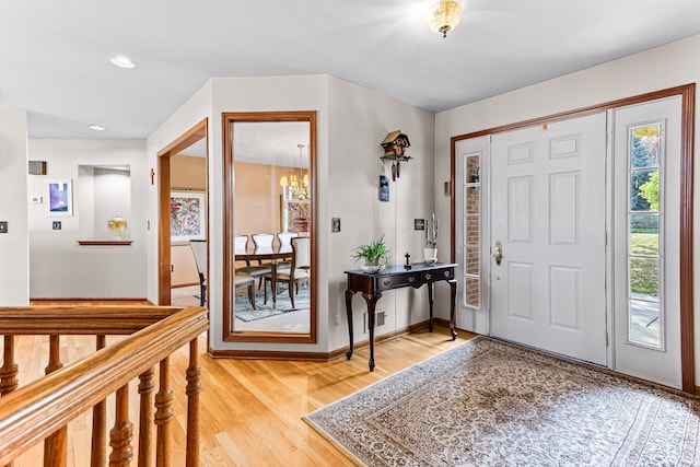 foyer entrance featuring recessed lighting, a notable chandelier, baseboards, and light wood-style floors