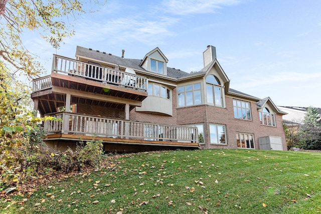 back of property featuring a yard, brick siding, and a chimney