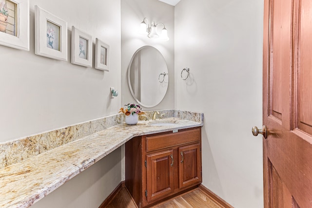 bathroom with vanity, baseboards, and wood finished floors