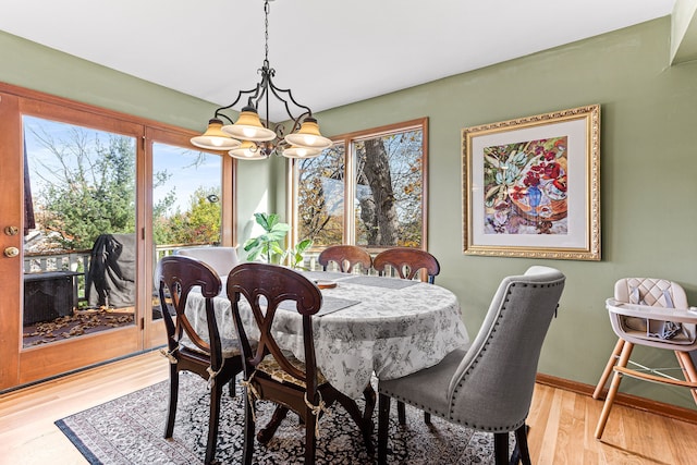 dining room featuring wood finished floors, baseboards, and a chandelier