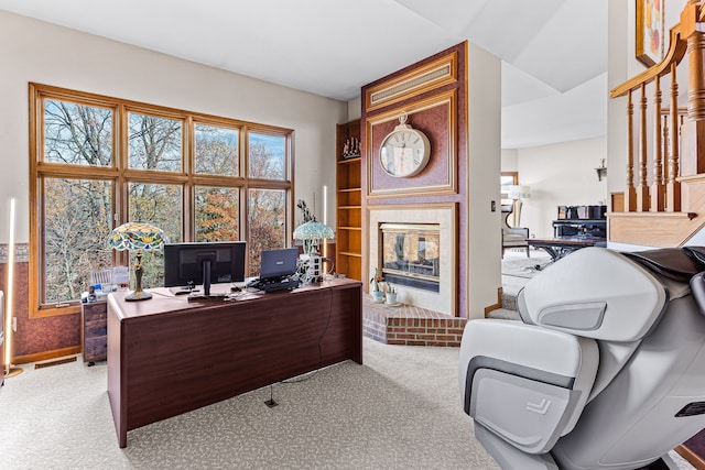 carpeted home office with a fireplace