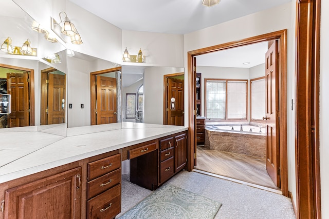 full bathroom featuring a garden tub and vanity