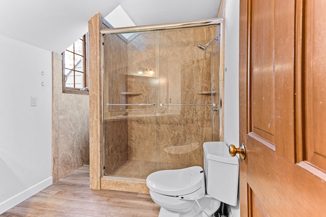 bathroom with a stall shower, toilet, lofted ceiling, and wood finished floors