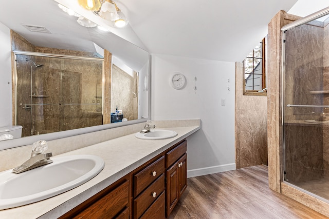 full bath featuring a sink, lofted ceiling, wood finished floors, and double vanity