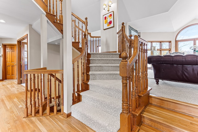 stairs featuring recessed lighting, lofted ceiling, baseboards, and wood finished floors