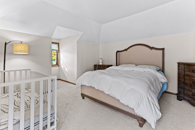 bedroom featuring baseboards, carpet, and vaulted ceiling