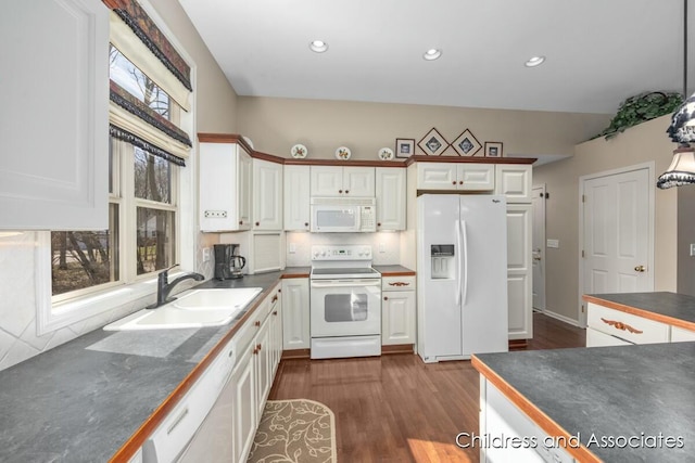 kitchen with white appliances, dark wood-style floors, a sink, white cabinetry, and dark countertops