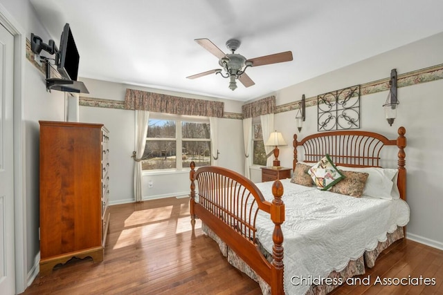 bedroom featuring baseboards, hardwood / wood-style floors, and a ceiling fan