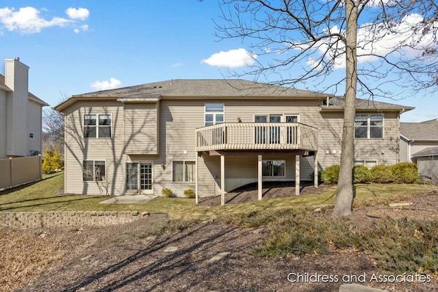 back of property featuring a deck, a yard, and fence