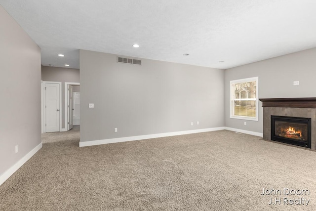 unfurnished living room with a fireplace, baseboards, visible vents, and carpet floors