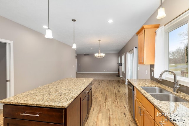 kitchen with light wood-style flooring, a center island, plenty of natural light, and a sink