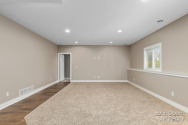 spare room with recessed lighting, visible vents, baseboards, and dark wood-style flooring