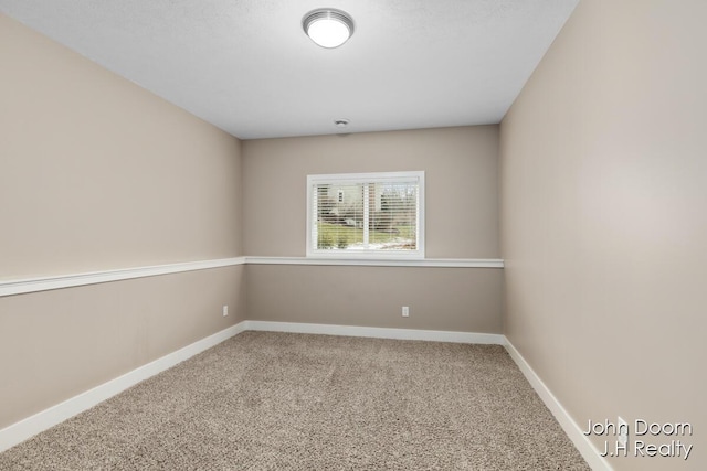 carpeted spare room with baseboards