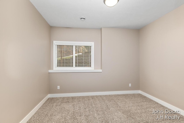 unfurnished room featuring baseboards and carpet