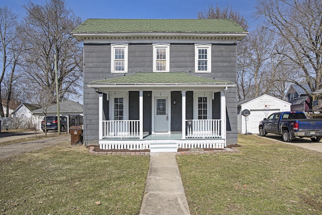 view of front of house featuring a porch, a garage, a front yard, and an outdoor structure