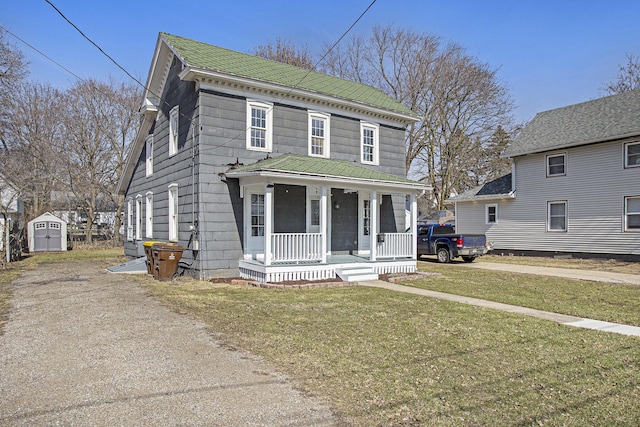 view of front of house with a storage shed, a porch, an outdoor structure, and a front lawn