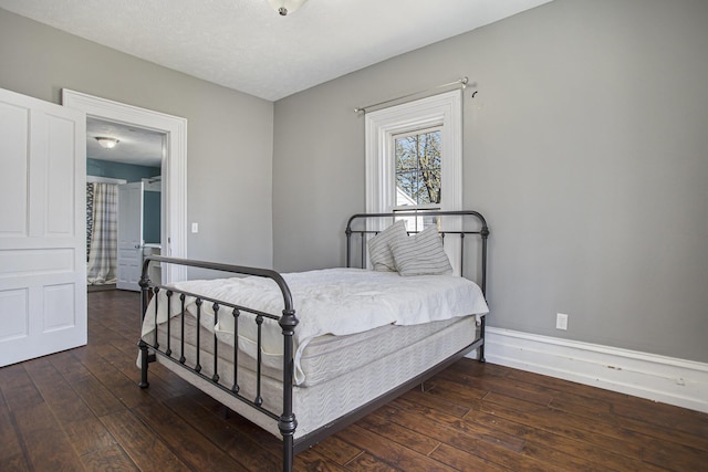 bedroom featuring baseboards and wood-type flooring