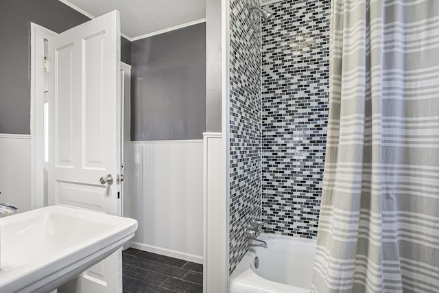 full bath with a sink, a wainscoted wall, ornamental molding, and shower / bath combination with curtain