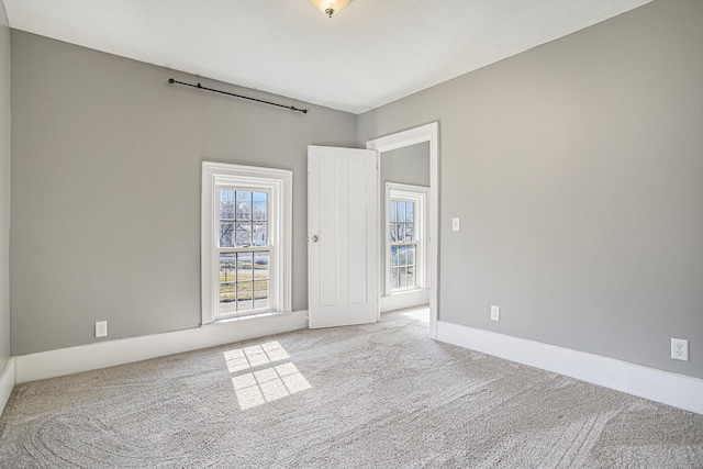 empty room featuring baseboards and carpet floors