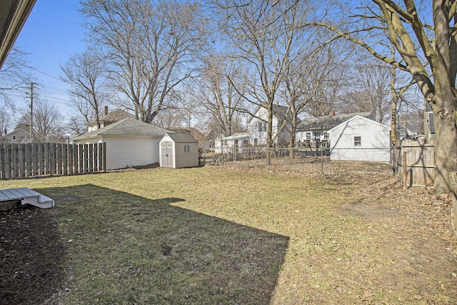 view of yard featuring a storage shed, an outbuilding, and a fenced backyard