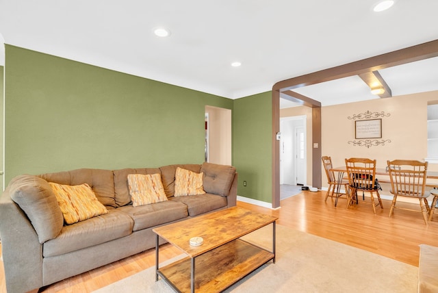 living room featuring recessed lighting, baseboards, and light wood finished floors