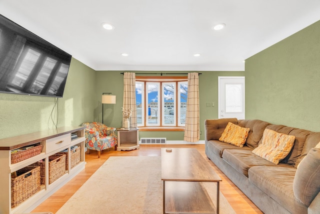 living area with recessed lighting, visible vents, and light wood-style flooring