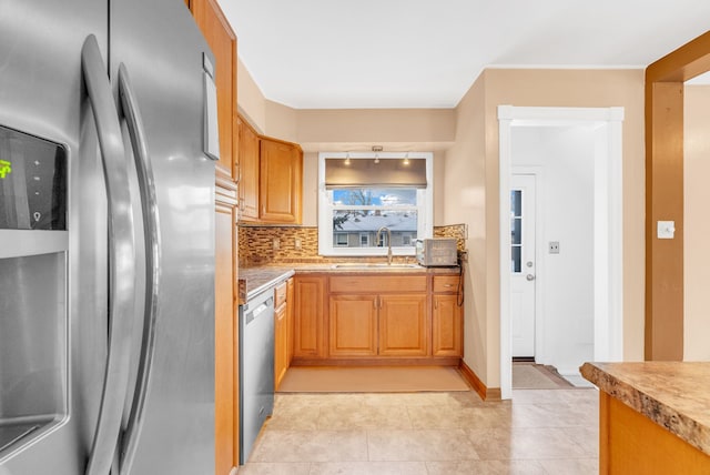 kitchen with light tile patterned floors, a sink, decorative backsplash, light countertops, and stainless steel appliances