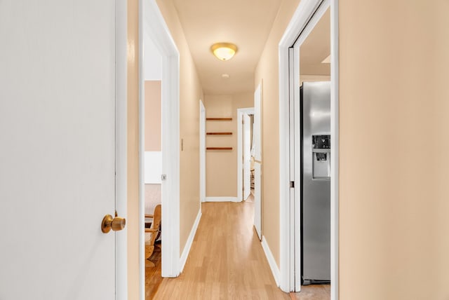 hall featuring baseboards and light wood-style flooring