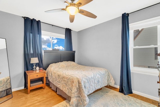 bedroom with baseboards, wood finished floors, and a ceiling fan