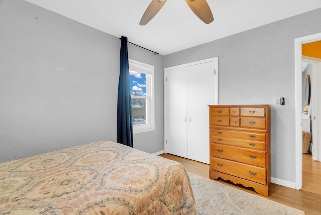 bedroom featuring ceiling fan, wood finished floors, a closet, and baseboards