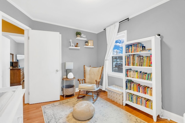 living area featuring crown molding, baseboards, and wood finished floors