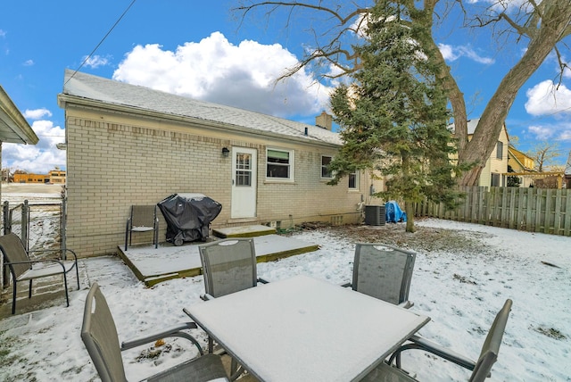 exterior space featuring outdoor dining space, fence, central AC, a patio area, and brick siding