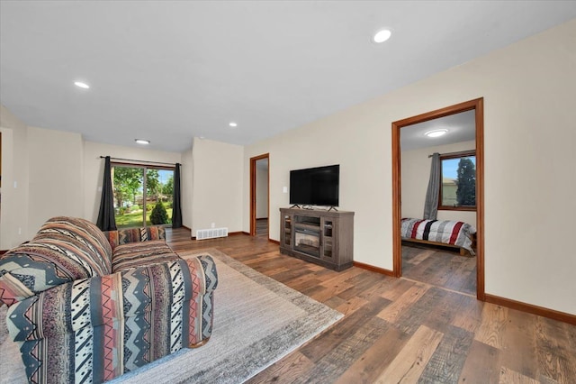 living area with recessed lighting, baseboards, and wood finished floors