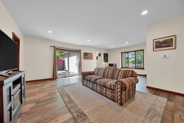 living area with plenty of natural light, wood finished floors, and baseboards