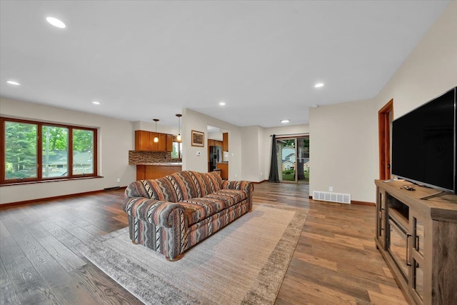 living area with visible vents, recessed lighting, and baseboards