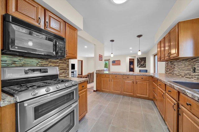 kitchen with decorative light fixtures, black microwave, range with two ovens, decorative backsplash, and light tile patterned floors