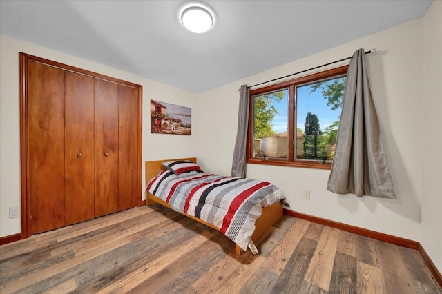 bedroom featuring a closet, baseboards, and wood finished floors