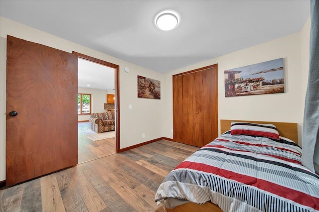 bedroom featuring wood finished floors, a closet, and baseboards