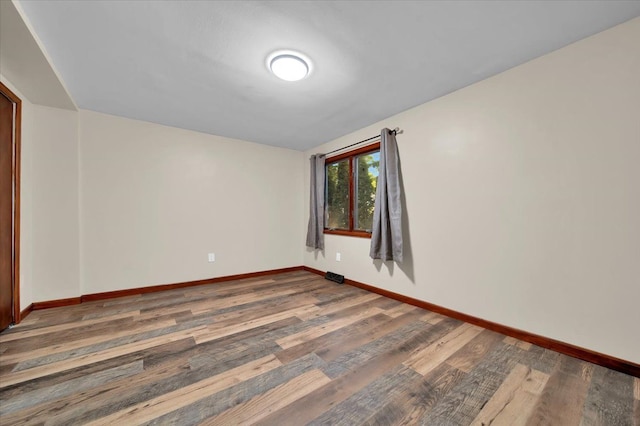 empty room featuring baseboards and wood finished floors