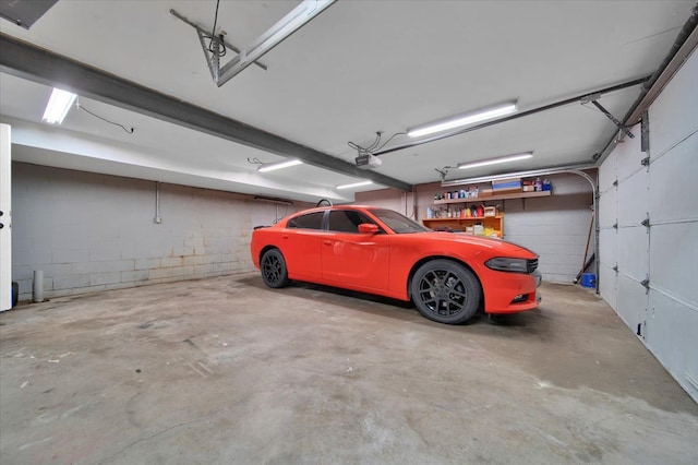 garage featuring a garage door opener and concrete block wall