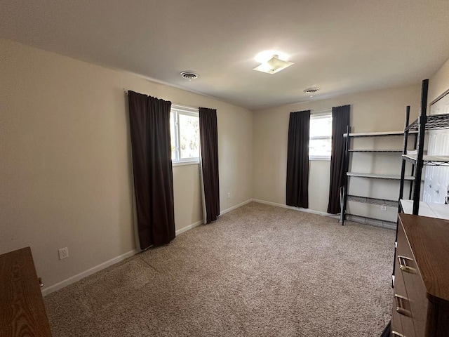 unfurnished bedroom featuring carpet, visible vents, and baseboards