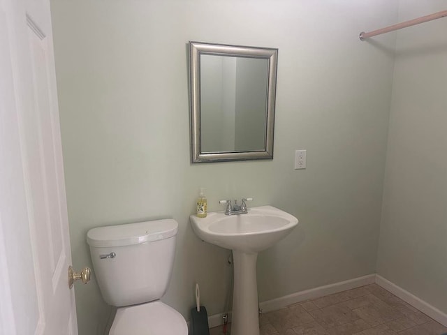 bathroom featuring toilet and baseboards