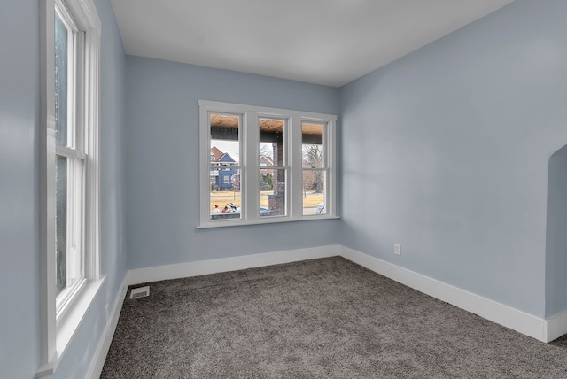 unfurnished room featuring carpet, visible vents, and baseboards