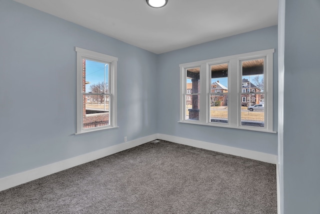 carpeted empty room with baseboards