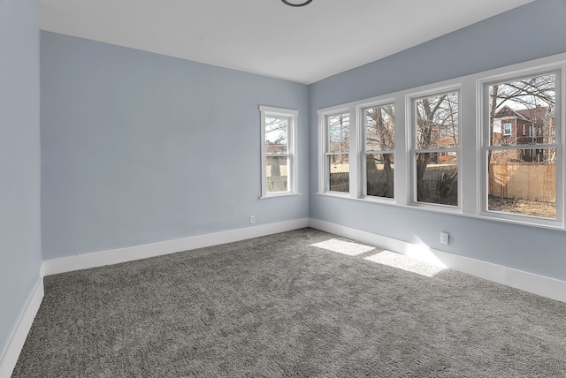 carpeted empty room featuring baseboards