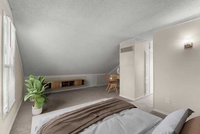 carpeted bedroom featuring visible vents, a textured ceiling, baseboards, and vaulted ceiling